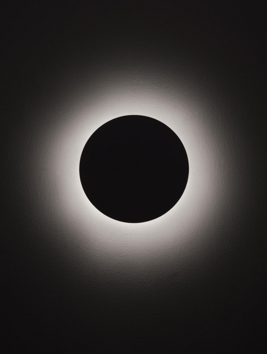 Solar eclipse with a dark central disk and bright outer ring on a black background