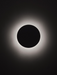 Solar eclipse with a dark central disk and bright outer ring on a black background