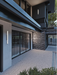 Modern house exterior with glass doors and stone wall
